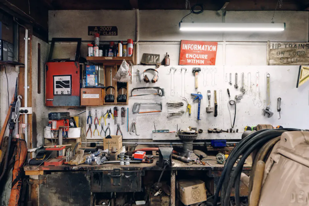 Hand tools, safety equipment and small parts arranged around a busy workshop bench.